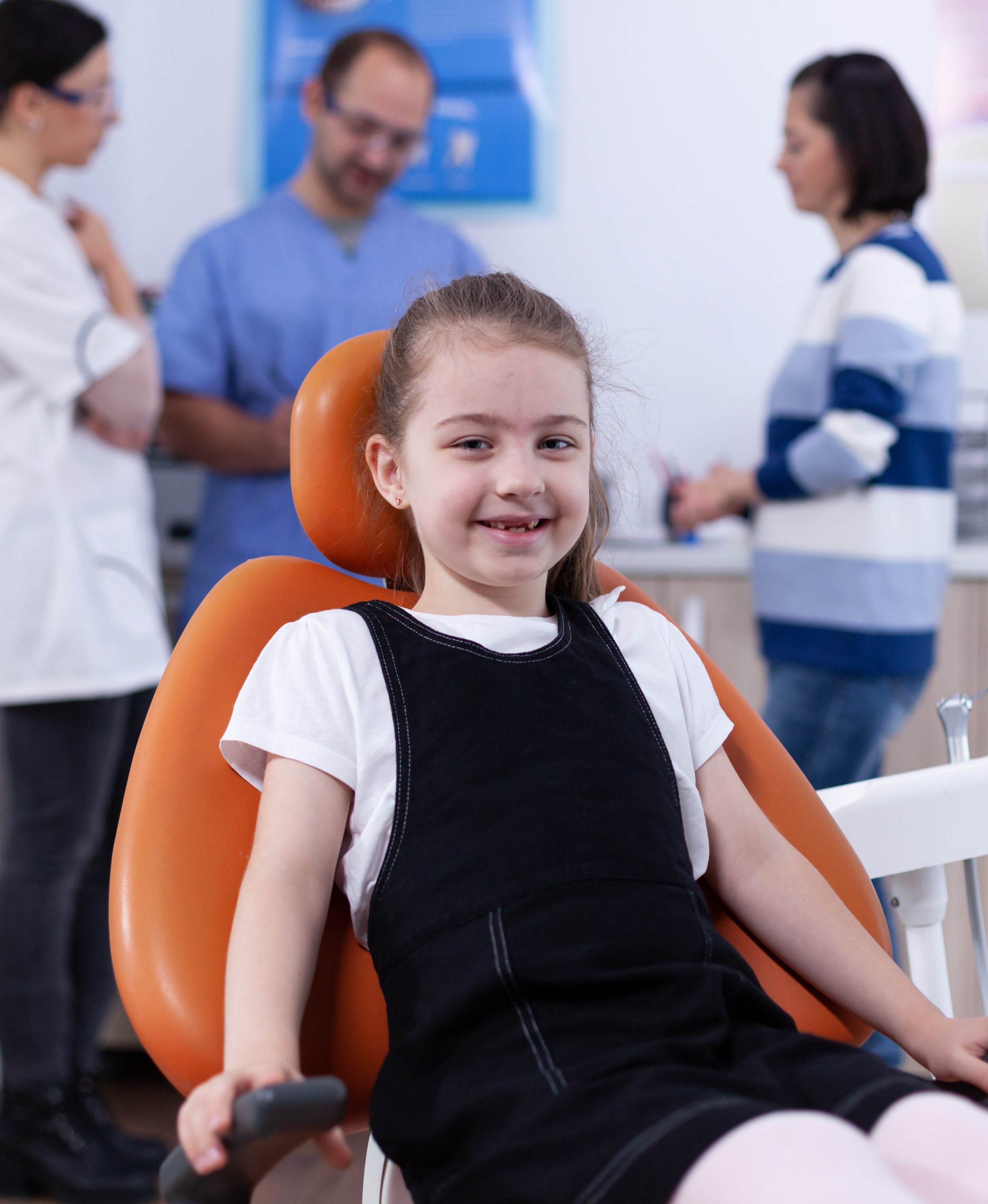 cheerful kid sitting chair dentist office during visit bad tooth treatment parent disscusing with doctor child with her mother during teeth check up with stomatolog sitting chair