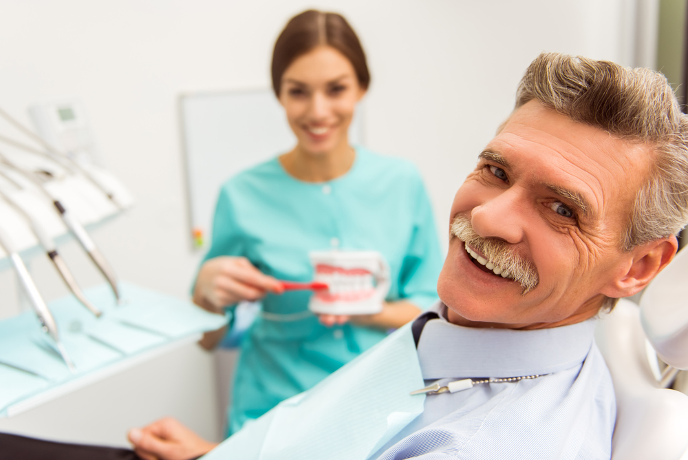 Dental Implant Maintenance, middle aged man smiling with a new dental implant