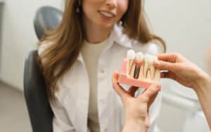 woman looking at a display for dental implants