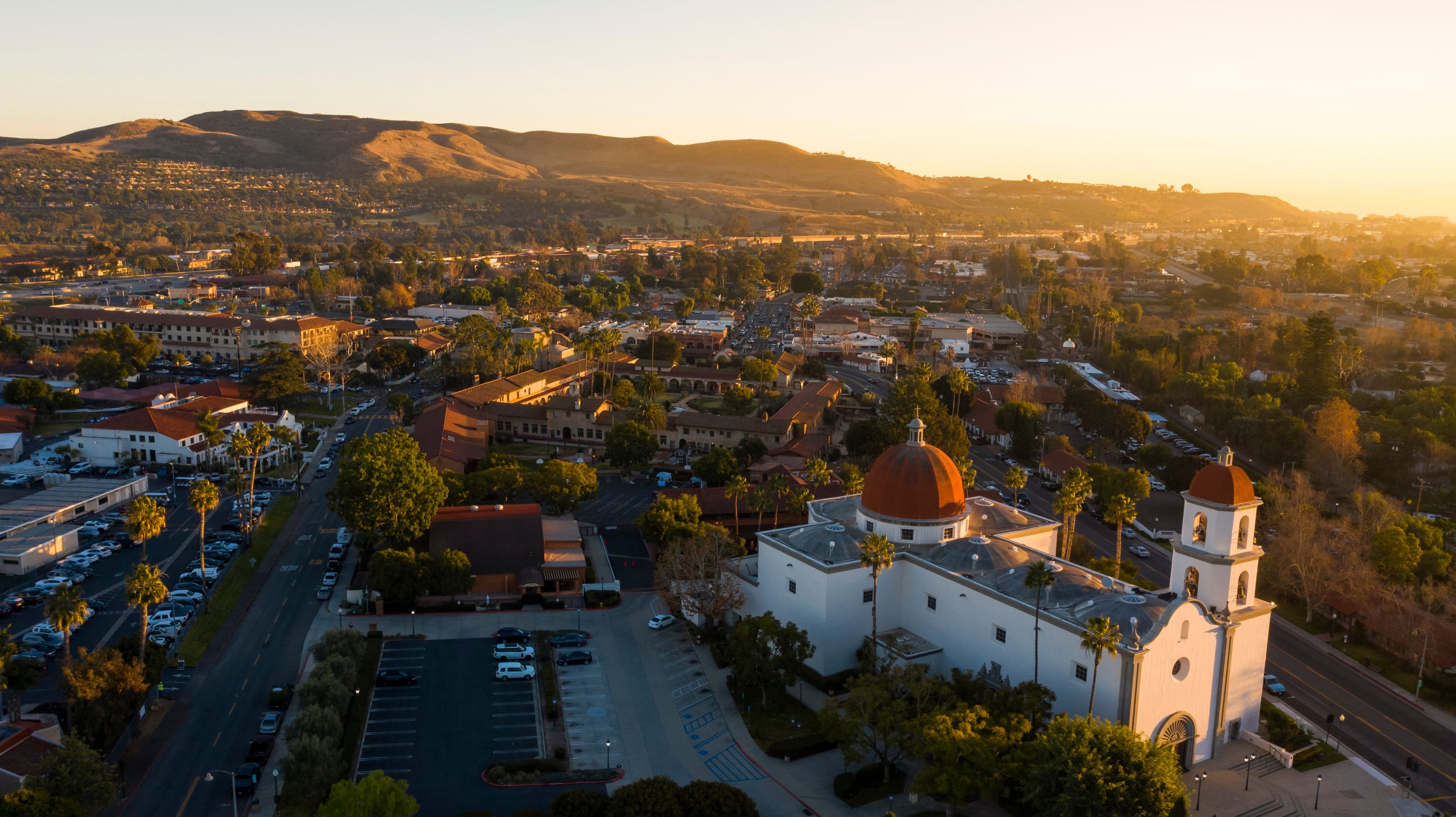 Sunset aerial view of the Spanish Colonial era mission and surrounding city of downtown San Juan Capistrano, California, USA.