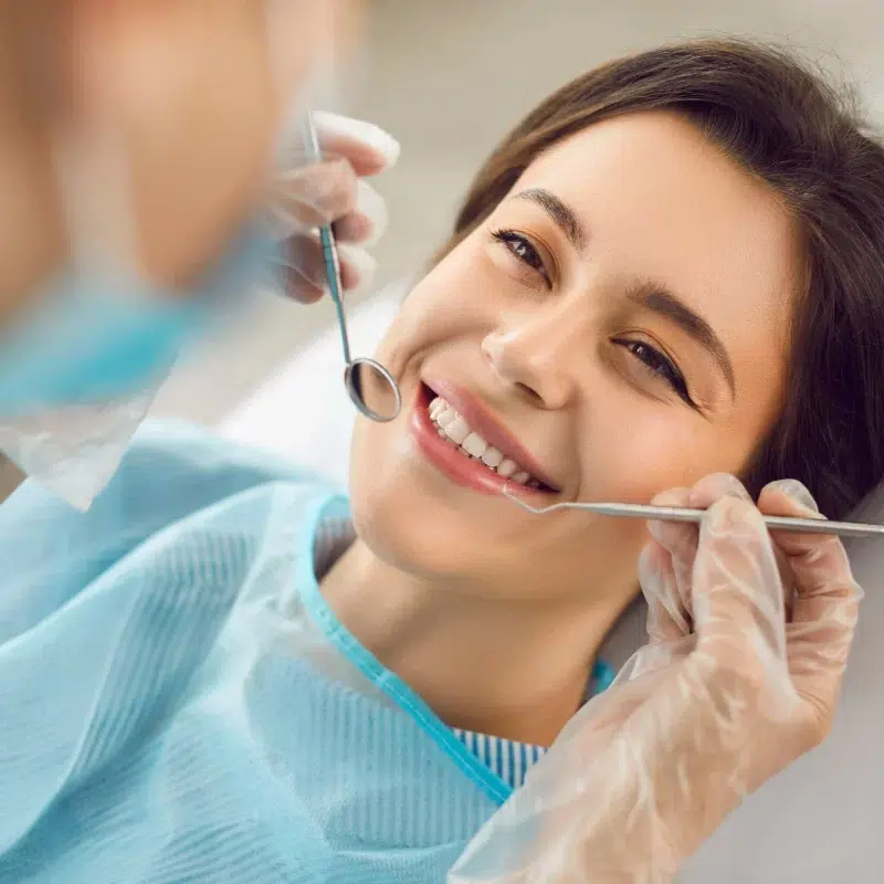 Woman smiling during dental check-up after oral surgery