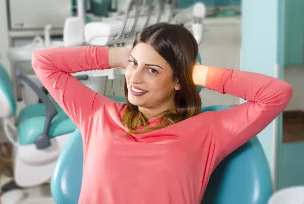 Woman smiling in dentist chair, relaxed and happy.